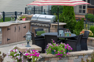 Terrasse mit Outdoor Küche, Gasgrill, Sonnenschirm und Essplatz.