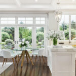Schönes Interieur mit Kunstblumen in weißer Küche und Wohnzimmer