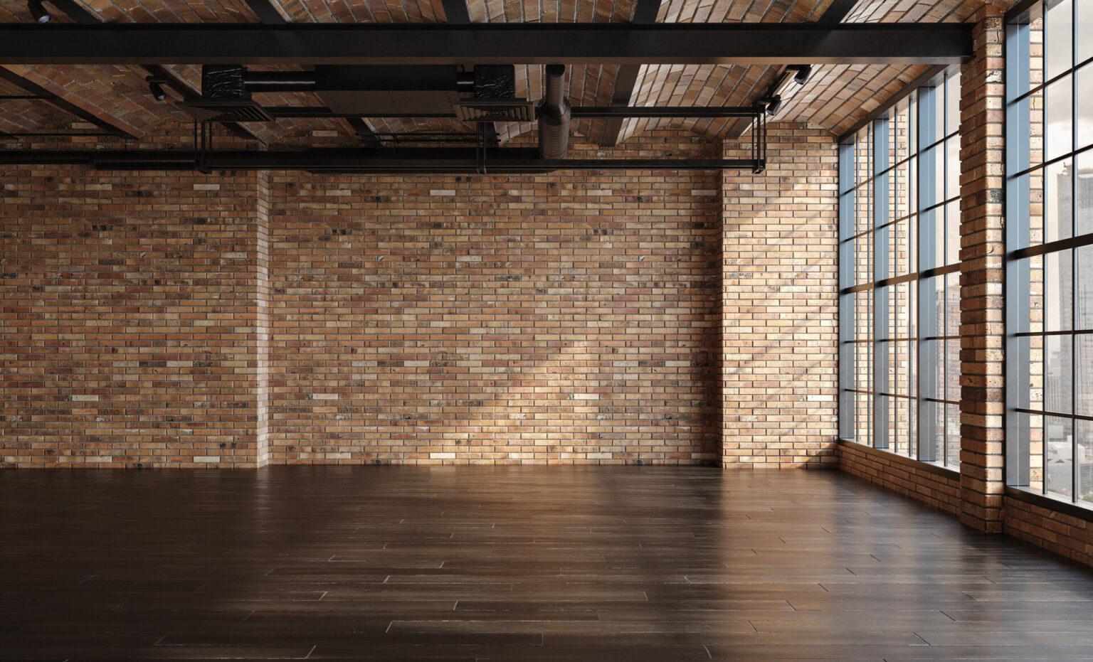 Leere Loft-Wohnung, Industriestil, gemauerte Wand, Holzfußboden und große, bodentiefe Fenster.